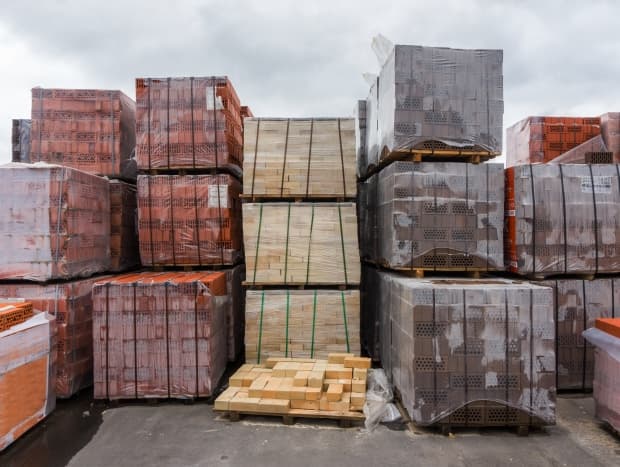 Interior de almacen industrial lleno de tarimas con materiales de construcción